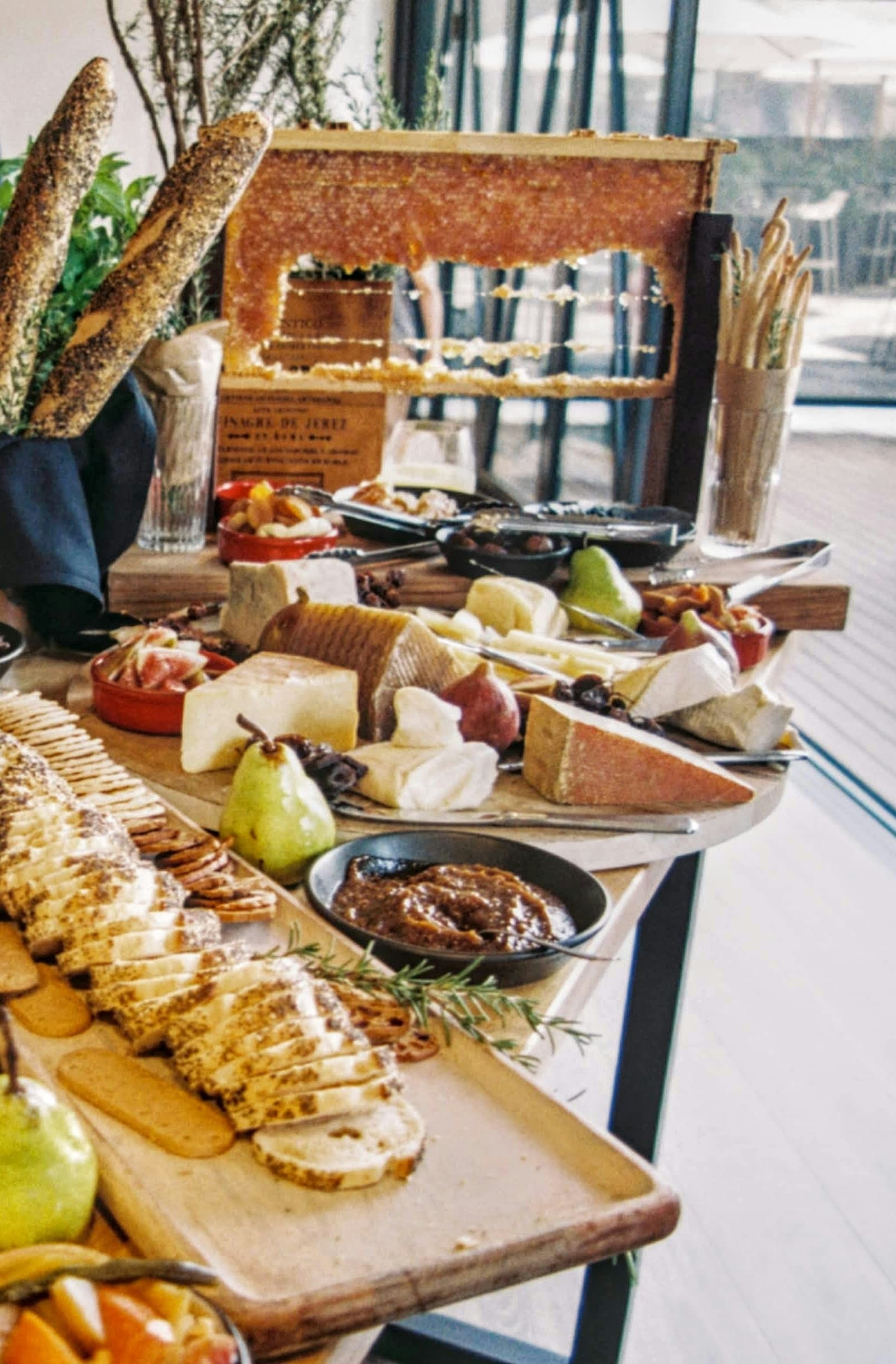 Catering-Anrichtplatte mit Käse, Brot, Früchten und Honigwabe